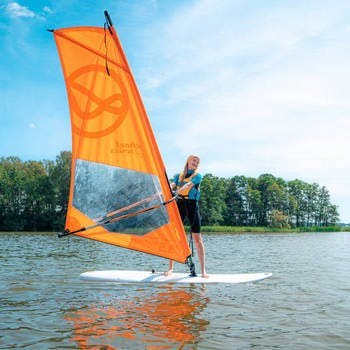 Dziewczyna płynąca na desce windsurfingowej